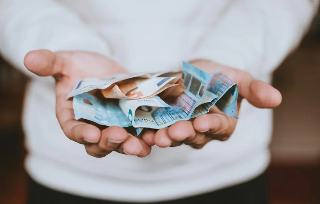 Mãos segurando cédulas de euros
