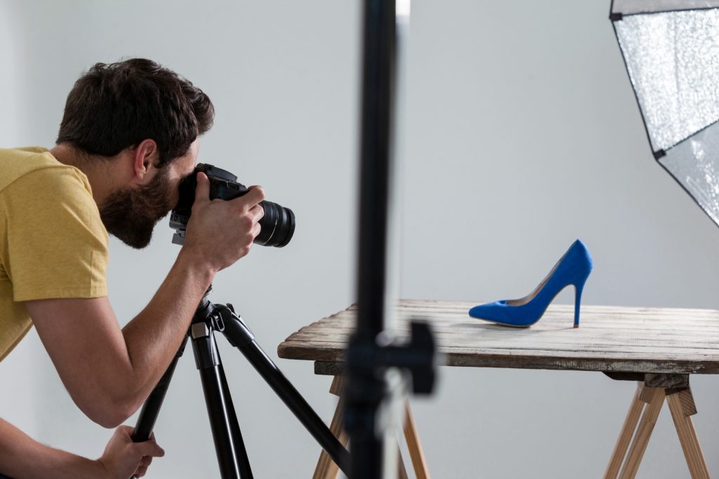Homem fotografando em estúdio sapato azul