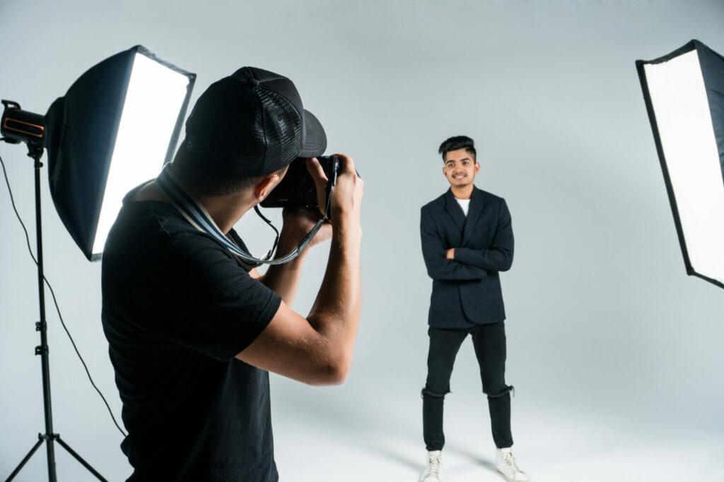 Fotógrafo fotografando homem em estúdio