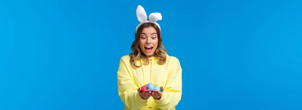 A imagem mostra uma mulher segurando alguns ovos de páscoa