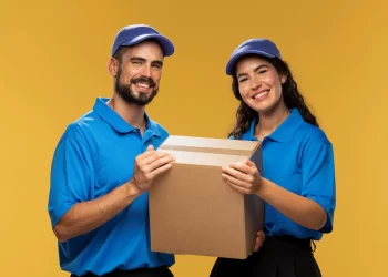 Dois entregadores segurando uma caixa de encomenda, representando serviços de Correios ou transportadora