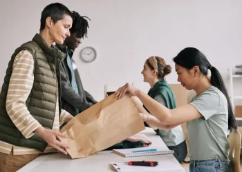 Equipe embalando encomenda para envio, representando o processo de coleta do pedido no centro logístico