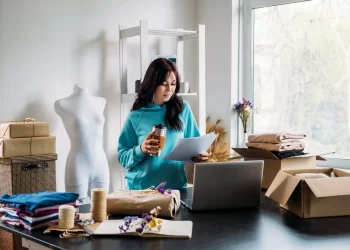 Empreendedora organizando pedidos em loja virtual, ilustrando a logística para e-commerce com foco em envios e embalagens