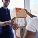 Entregador sorridente entregando encomendas para cliente, representando o frete Curitiba com entregas rápidas e seguras