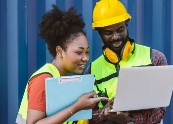 Profissionais da logística conferindo rastreamento no notebook, representando o uso do Jet Express rastreio no e-commerce.