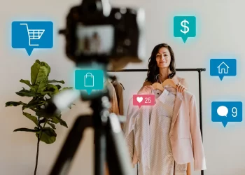 Mulher gravando vídeo de vendas com roupas, ilustrando o conceito de social commerce em redes sociais como Instagram e TikTok