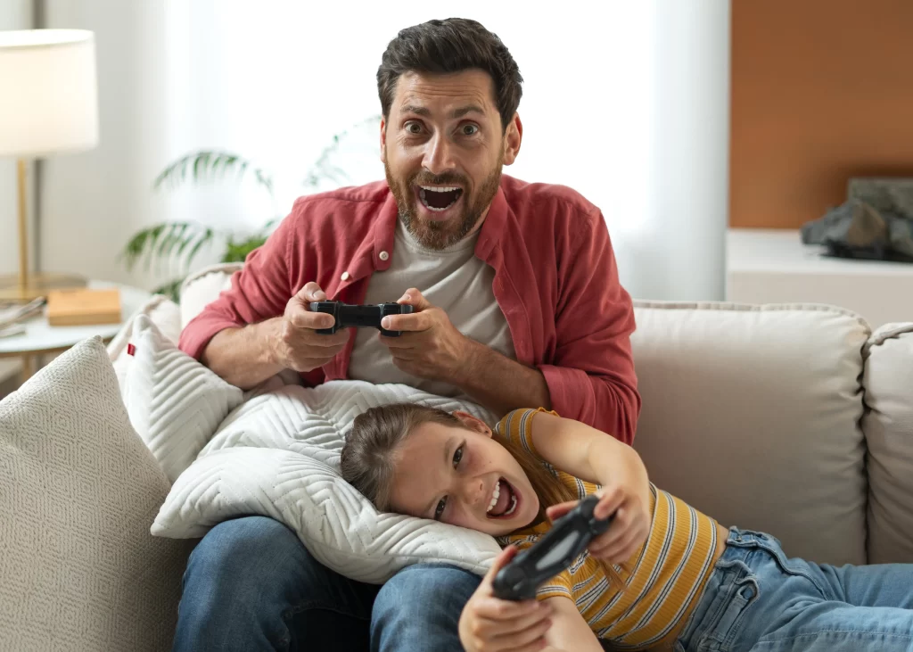 homem jogando video-game com sua filha