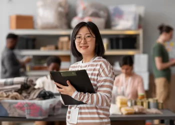 Empreendedora segurando prancheta em estoque de loja, representando microempresa enquadrada no Simples Nacional.