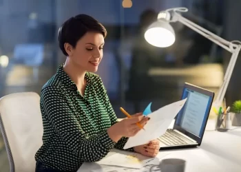 Empresária analisando documentos fiscais no computador para usar o DEC-eletrônica