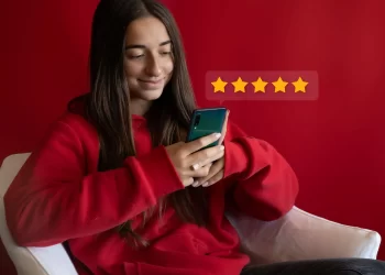 Cliente satisfeita deixando avaliações para e-commerce com cinco estrelas pelo celular
