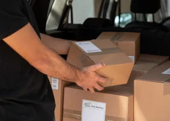 capa do artigo tipos de frete que mostra um homem segurando uma encomenda em caixa de papelão