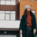 Mulher vestida de casaco, gorro e óculos escuro