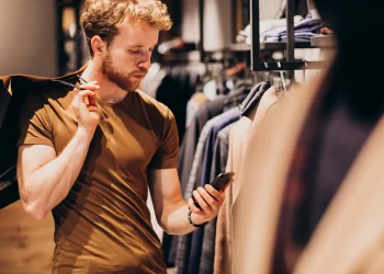 Homem caucasiano em loja de roupa masculina