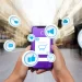 Celular com vários ícones relacionados a e-commerce e redes sociais saltando da tela.