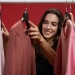 Mulher escolhendo roupas em cabide
