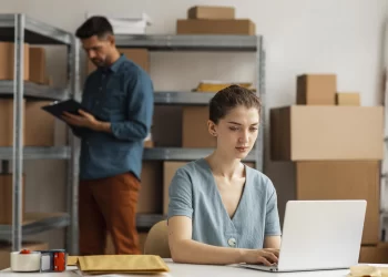 mulher utilizando notebook em uma sala de pedidos